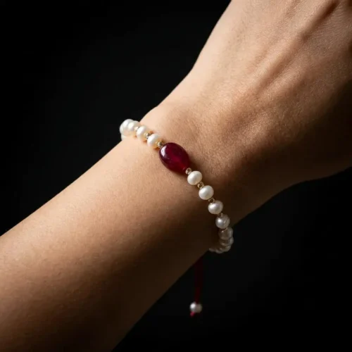 Bracelet ajustable sur cordon rouge avec perles d'eau douce جوهر حر, boules en or 18k et pierre centrale rouge au Maroc.