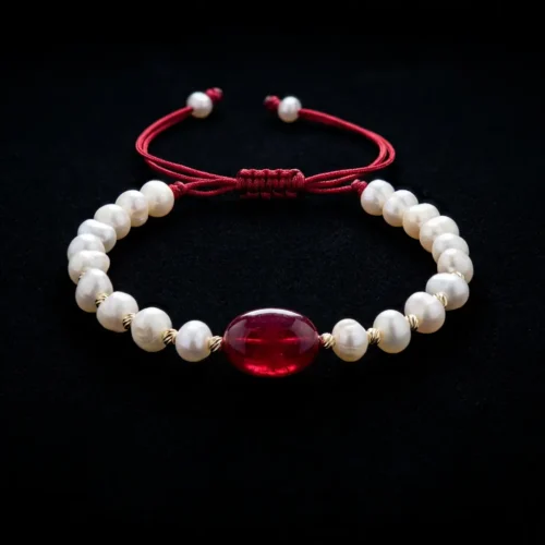 Bracelet ajustable sur cordon rouge avec perles d'eau douce جوهر حر, boules en or 18k et pierre centrale rouge au Maroc.